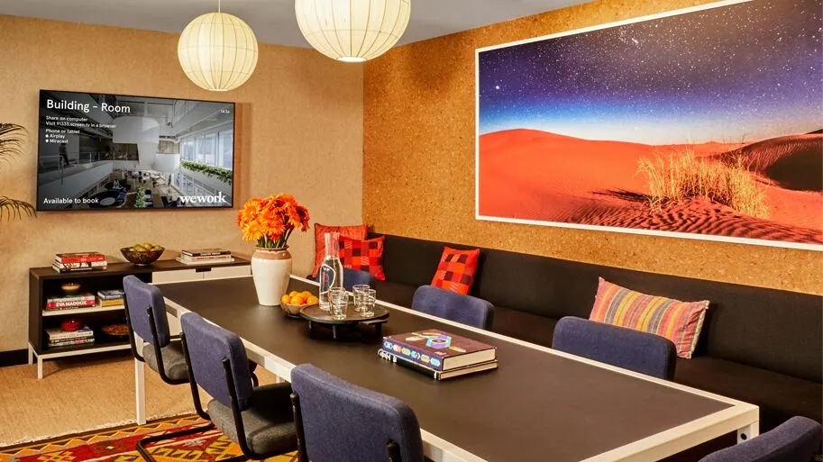 WeWork meeting space with a Mersive display showing wireless sharing and room booking information